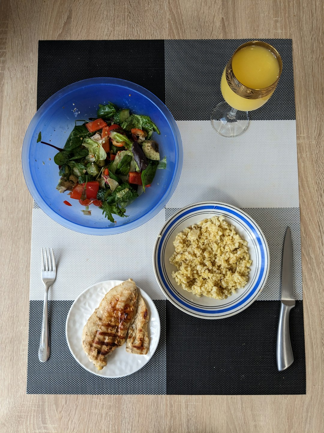a table topped with plates of food and a glass of orange juice