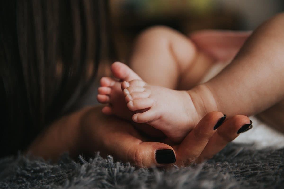 Pieds de bébé dans la main de sa maman : frein de lèvre ou frein de langue ?